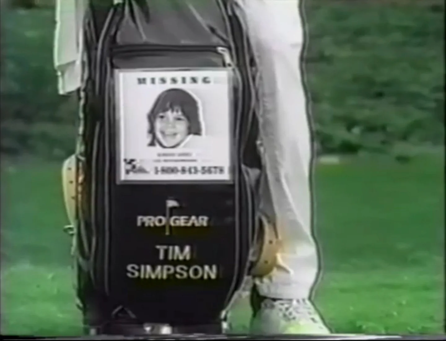 Golf bag with a missing child poster and name Tim Simpson.