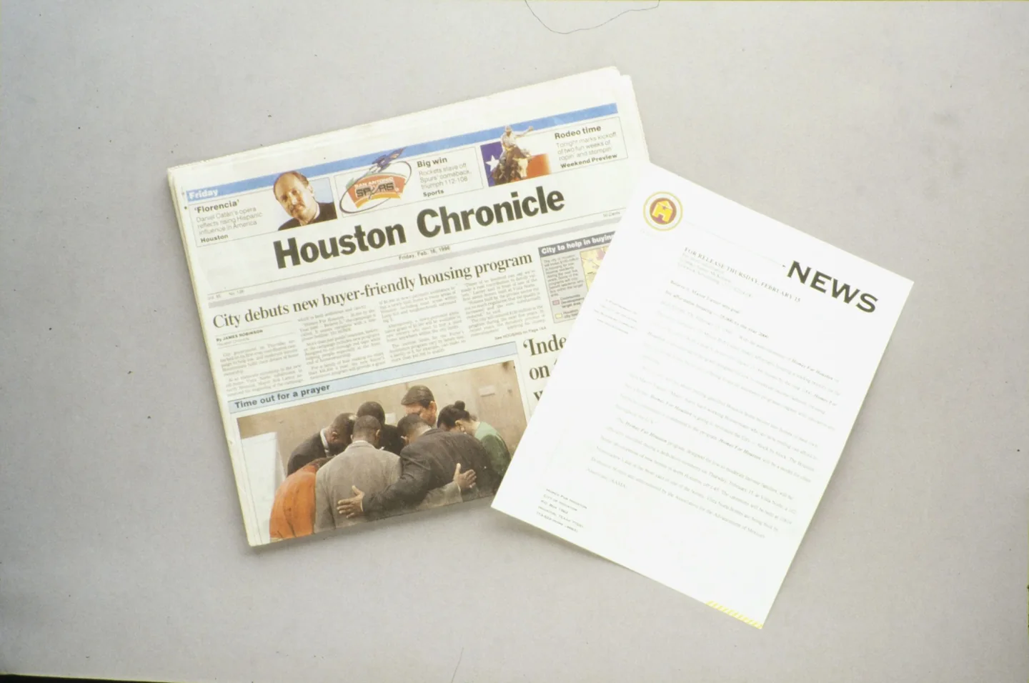 Houston Chronicle newspaper and a news document on a table.