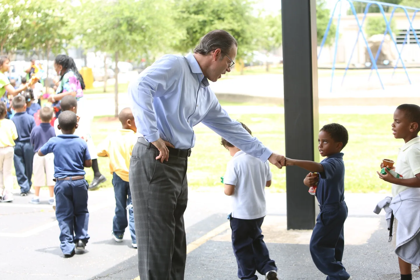 David Goswick greeting a student outdoors during a community learning activity.